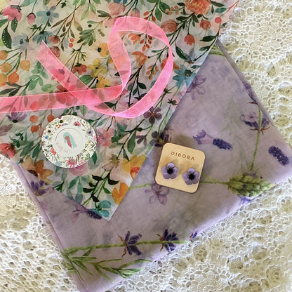 Floral purple scarf with a pair of earrings with floral tissue paper, pink ribbon and a gift tag