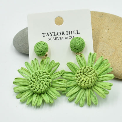 Green flower-shaped earrings on a Taylor Hill branded card.