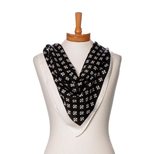 Black scarf with cream floral pattern draped over a mannequin on a white background