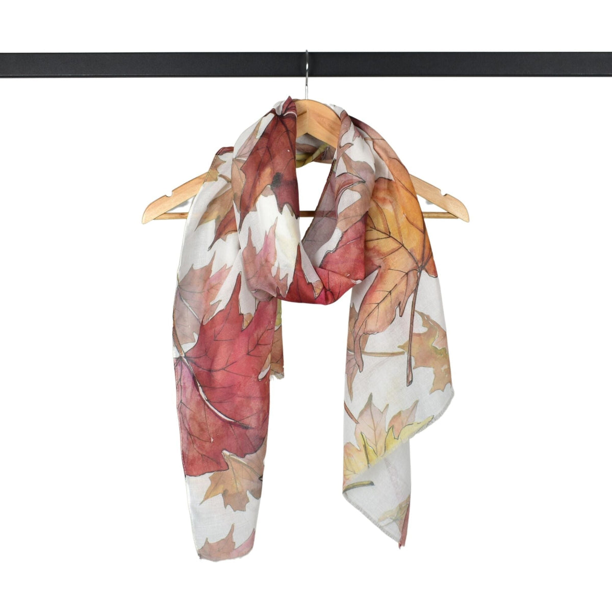 Scarf with autumn leaf pattern on a hanger against a white background
