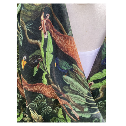 A white top with  a jungle-themed pattern scarf featuring animals and foliage.
