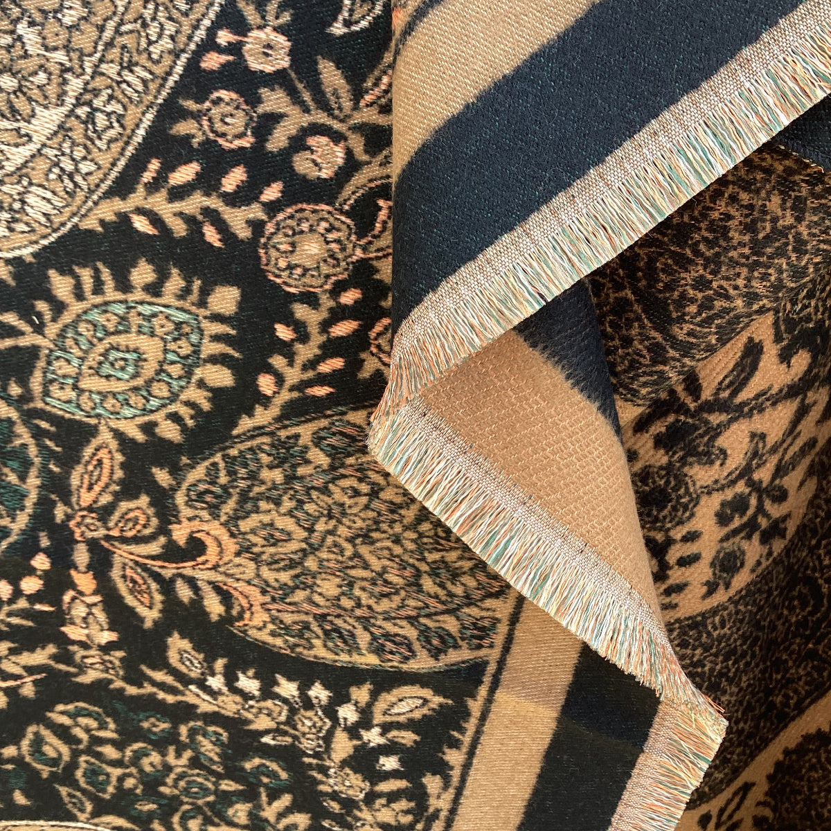 Close-up of patterned ladies scarf with intricate designs and fringes.