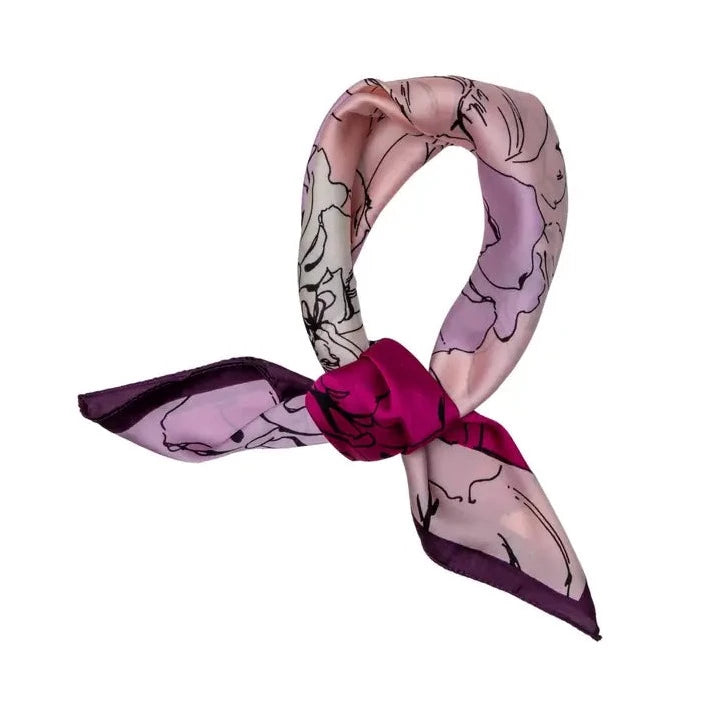 a satin ladies scarf with fuchsia pink and pale pink flowers and a dark purple border that has been tied in a know