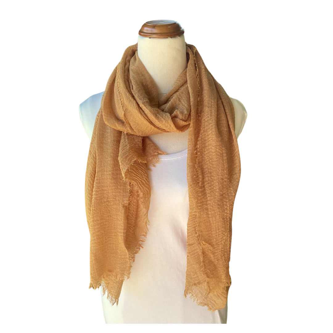 a light brown coloured scarf on a mannequin that has a textured weave and a frayed edge.