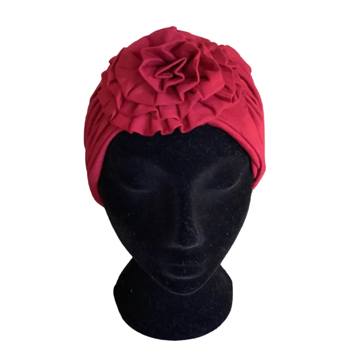 Red turban on a black mannequin head with a large flower at the front