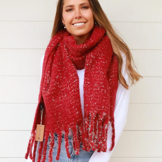 Woman wearing a red scarf gold glitter and tassels against a white background