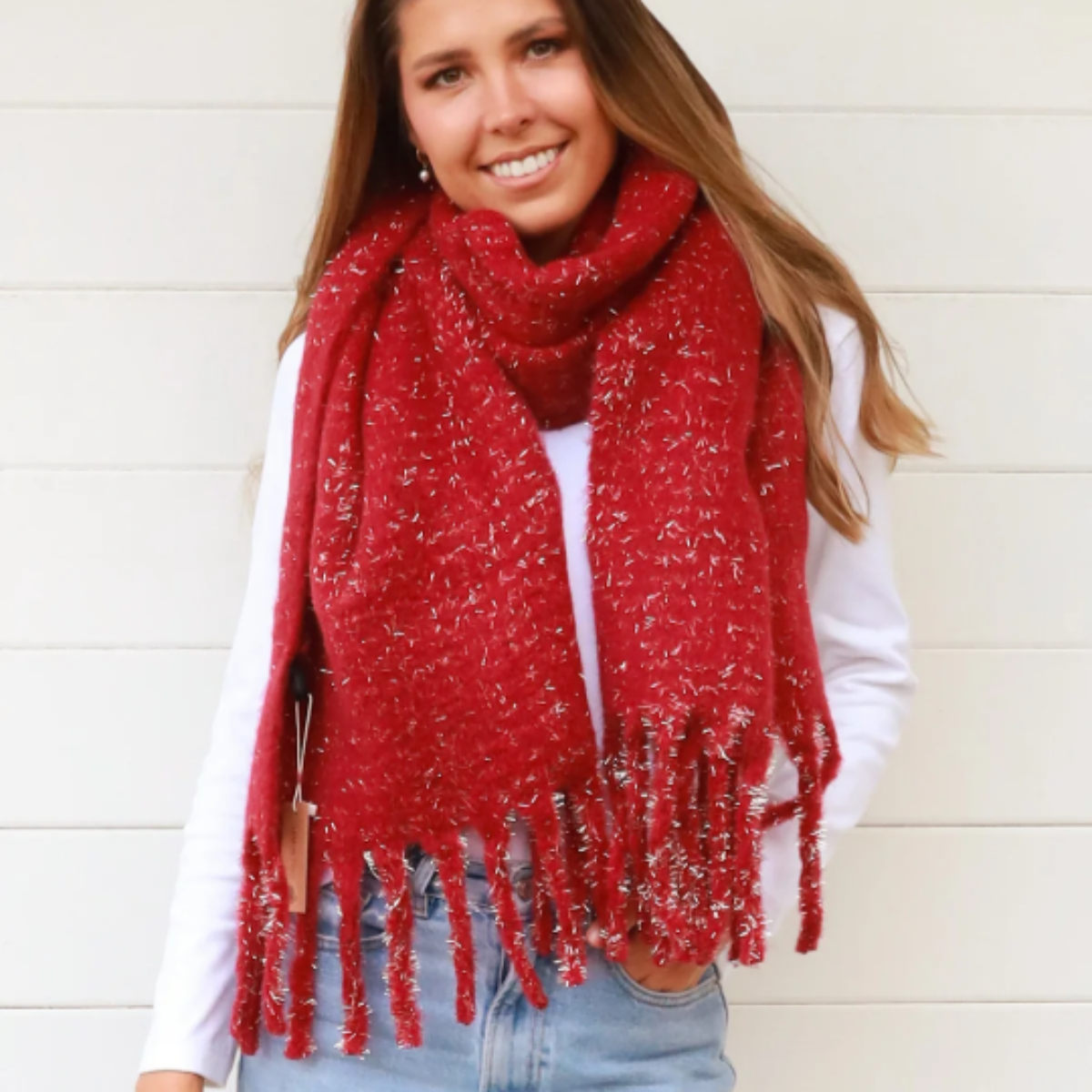 Woman wearing a red scarf with gold glitter thread and a white background