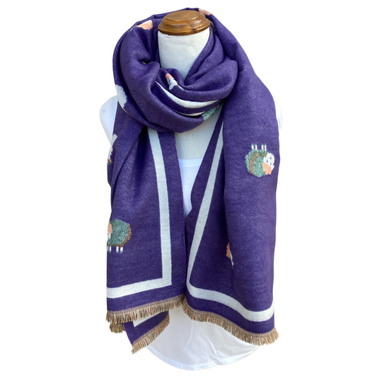 A purple knit scarf with white stripes and sheep pattern, draped on a white mannequin torso against a plain white background.