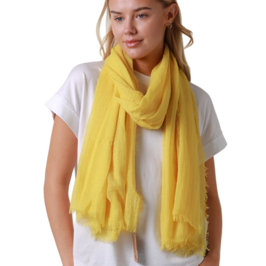Woman wearing a yellow scarf and white shirt on a white background