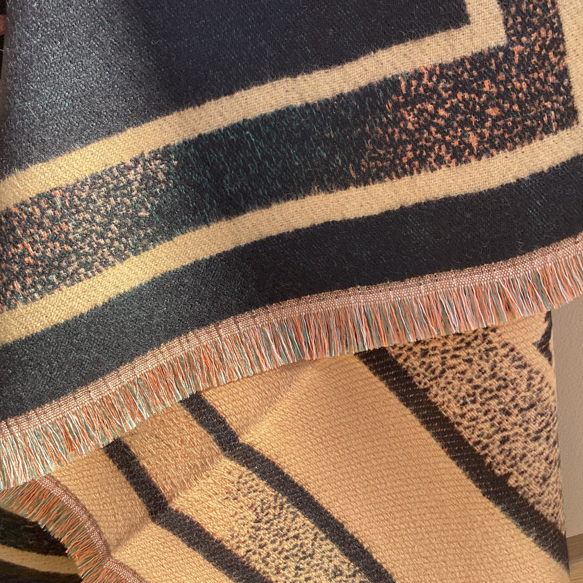 Close-up of a textured scarf showing the border and eyelash fringe