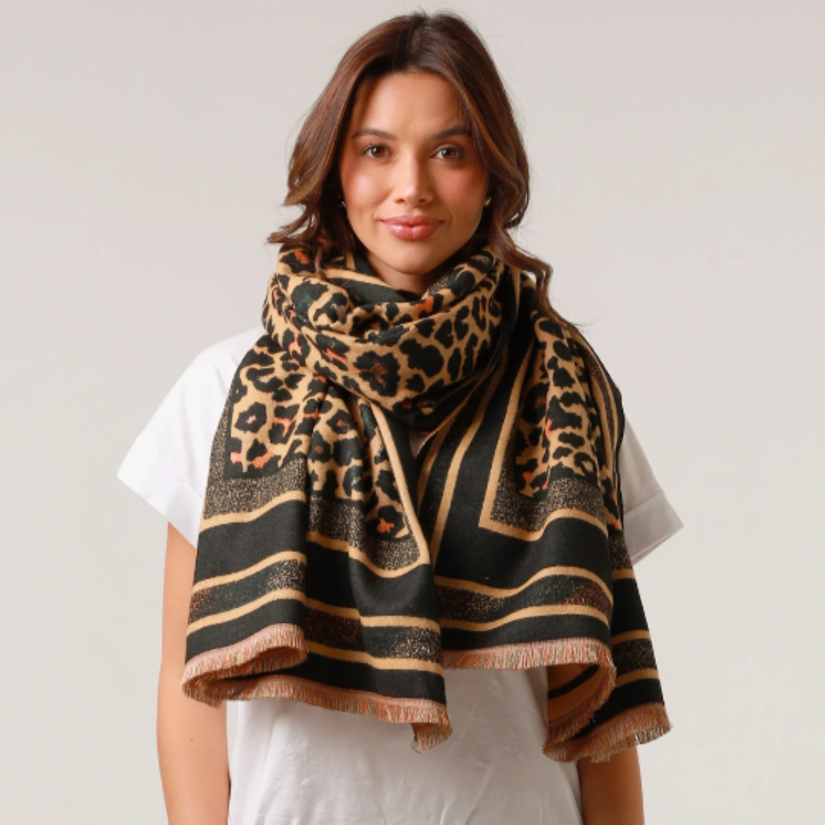 Woman wearing a leopard print scarf on a plain background