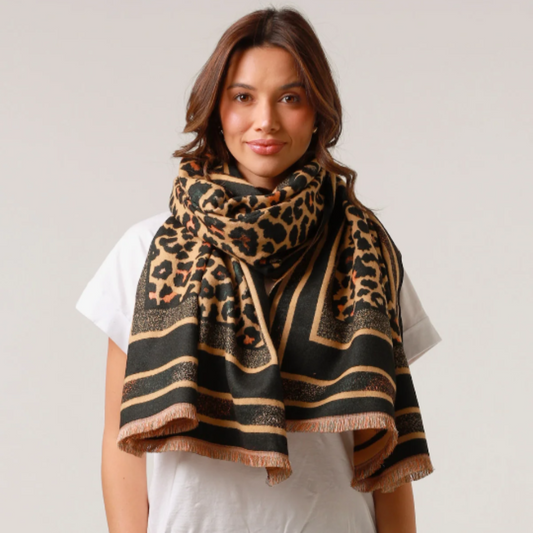 Woman wearing a leopard print scarf on a plain background