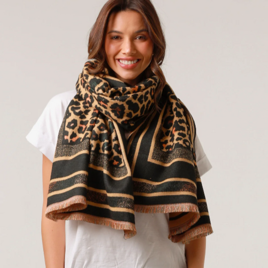 Woman wearing a leopard print scarf on a plain background