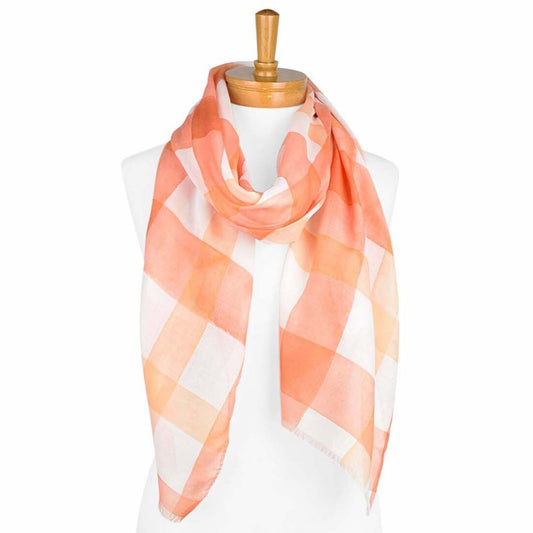 a ladies scarf that has a white background and an orange gingham pattern that has a watercolour effect