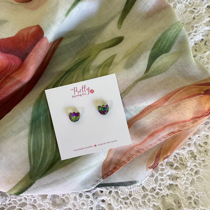 Pair of earrings on a card with floral fabric background
