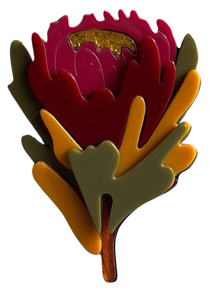 Colorful flower-shaped brooch with a white background