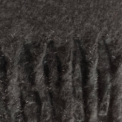Close-up of soft and warm black knit scaf with a silver metallic thread and chunky tassels