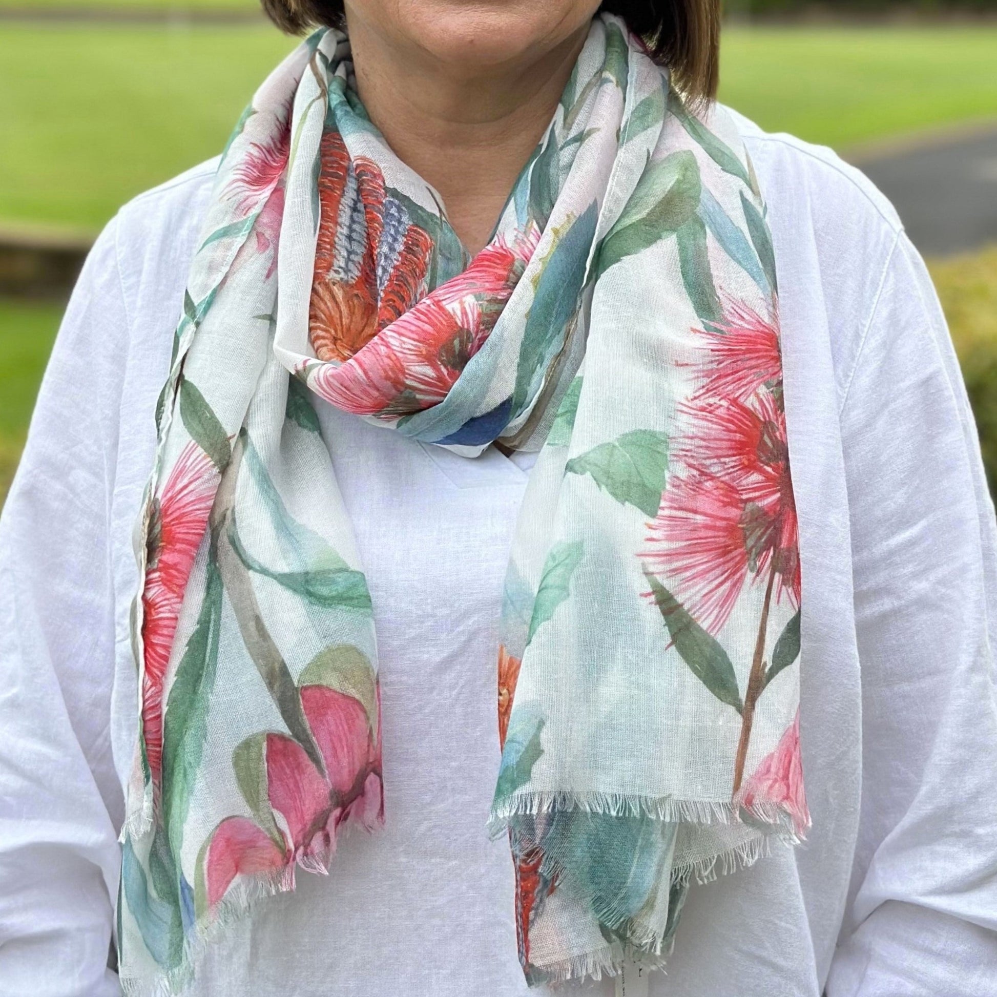 a lady wearing a scarf with waratah, banksia and bottlebrush flowers with green leaves