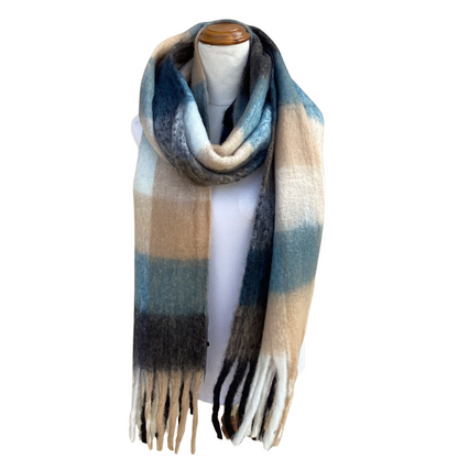 A long, soft striped scarf with fringe ends, draped on a white mannequin torso. The scarf features horizontal stripes in beige, light blue, slate blue, dark gray, and white.