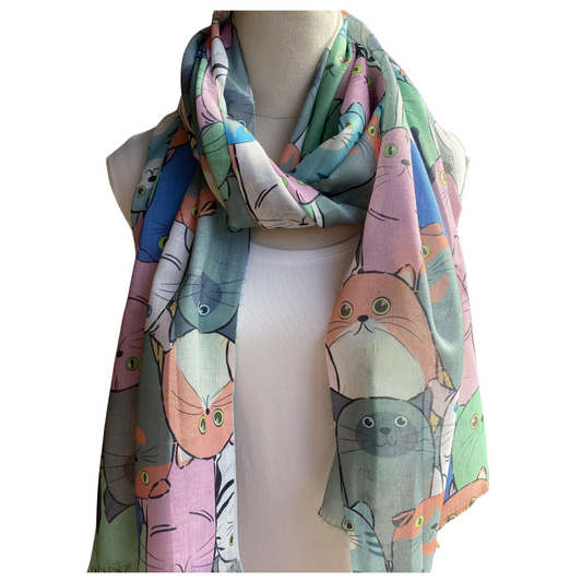 a ladies scarf that has large cat faces in colours of grey, blue, apricot and pink.