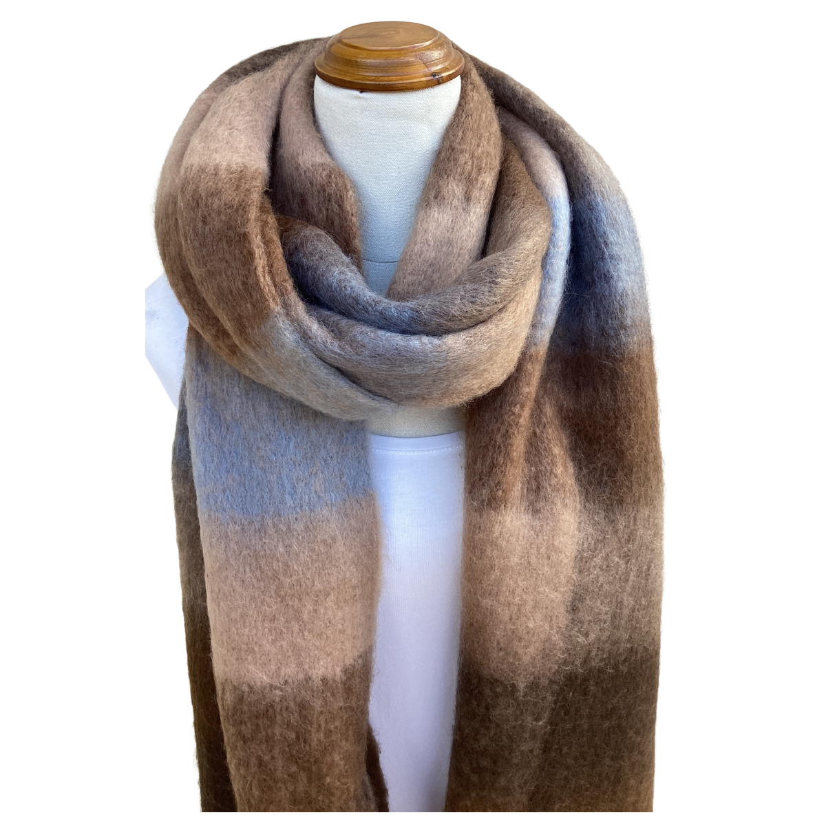 A soft, fuzzy scarf with a large gradient block pattern in shades of brown, beige, and muted blue-gray, draped on a white mannequin torso with a wooden cap.