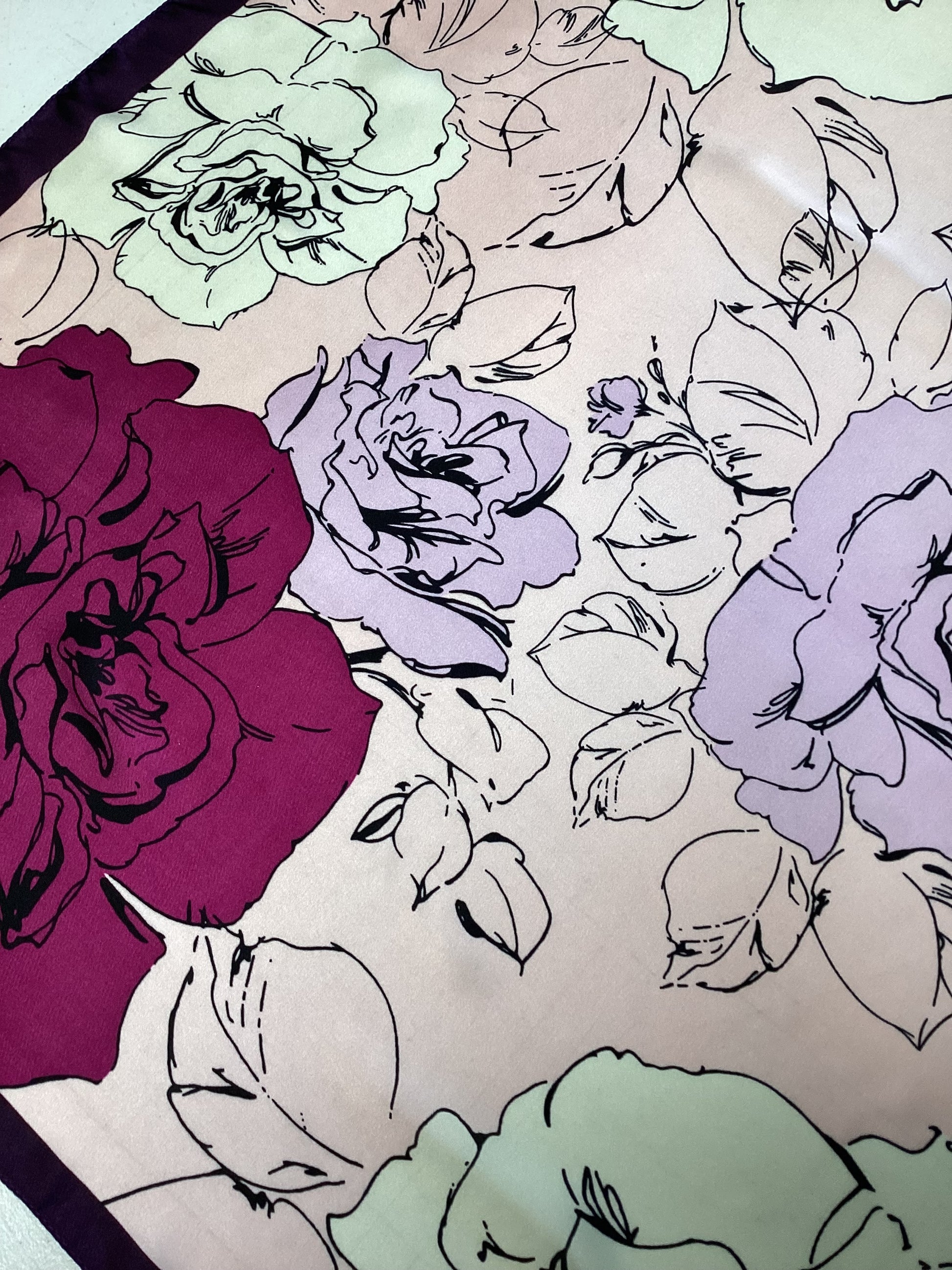 a satin ladies scarf with fuchsia pink and pale pink flowers and a dark purple border