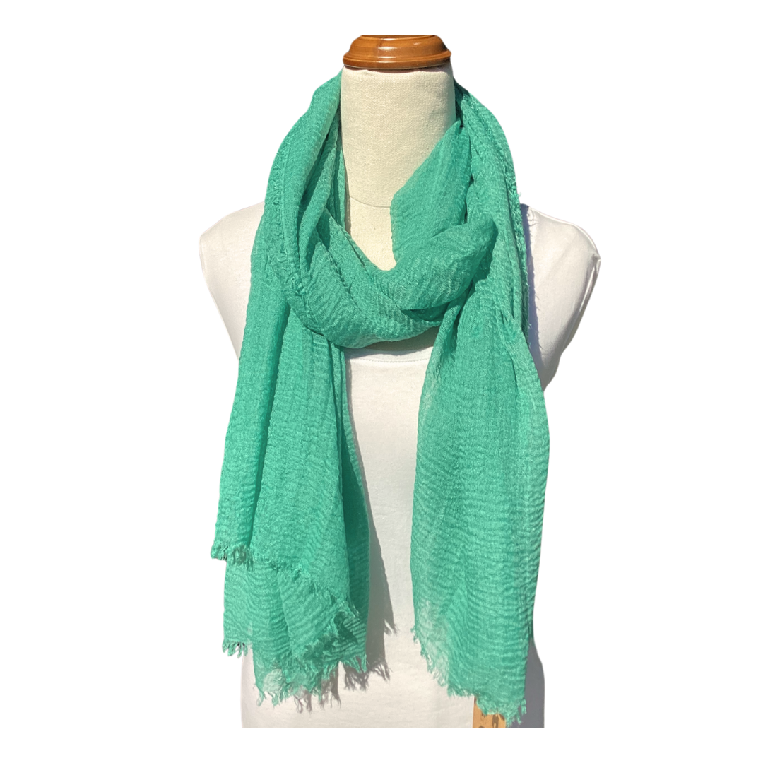 a plain ladies scarf that is jade green in colour and has a textured weave and frayed edges