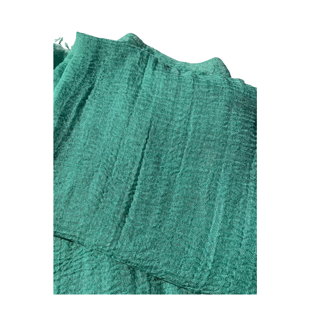 a plain ladies scarf that is jade green in colour and has a textured weave and frayed edges