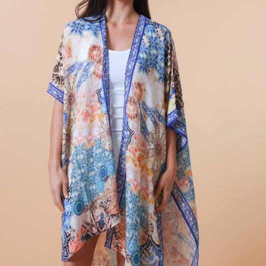 Woman wearing a blue abstract design kimono over a plain top against a beige background