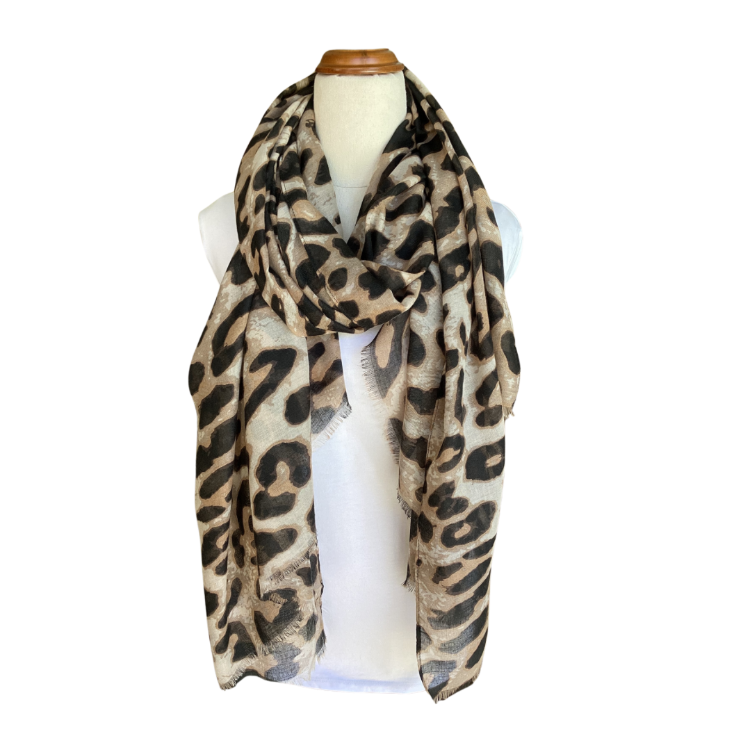 a ladies scarf tied on a mannequin with a leopard print in colours of black, tan, brown and cream