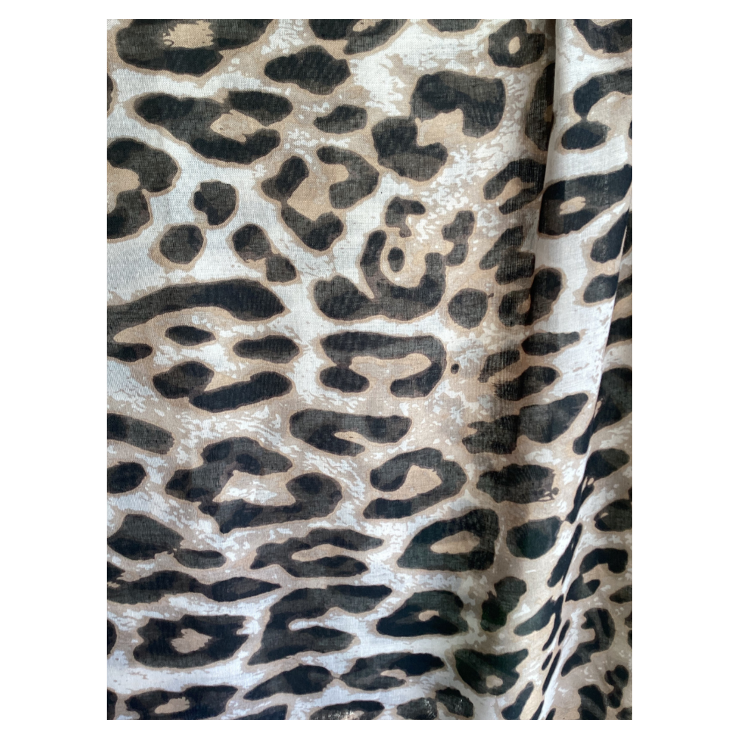 a ladies scarf close up of a leopard print in colours of black, brown and cream