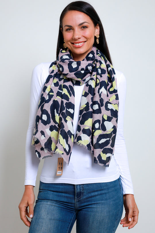 a lady wearing a leopard print scarf that has a purple background and navy and pale yellow leopard print