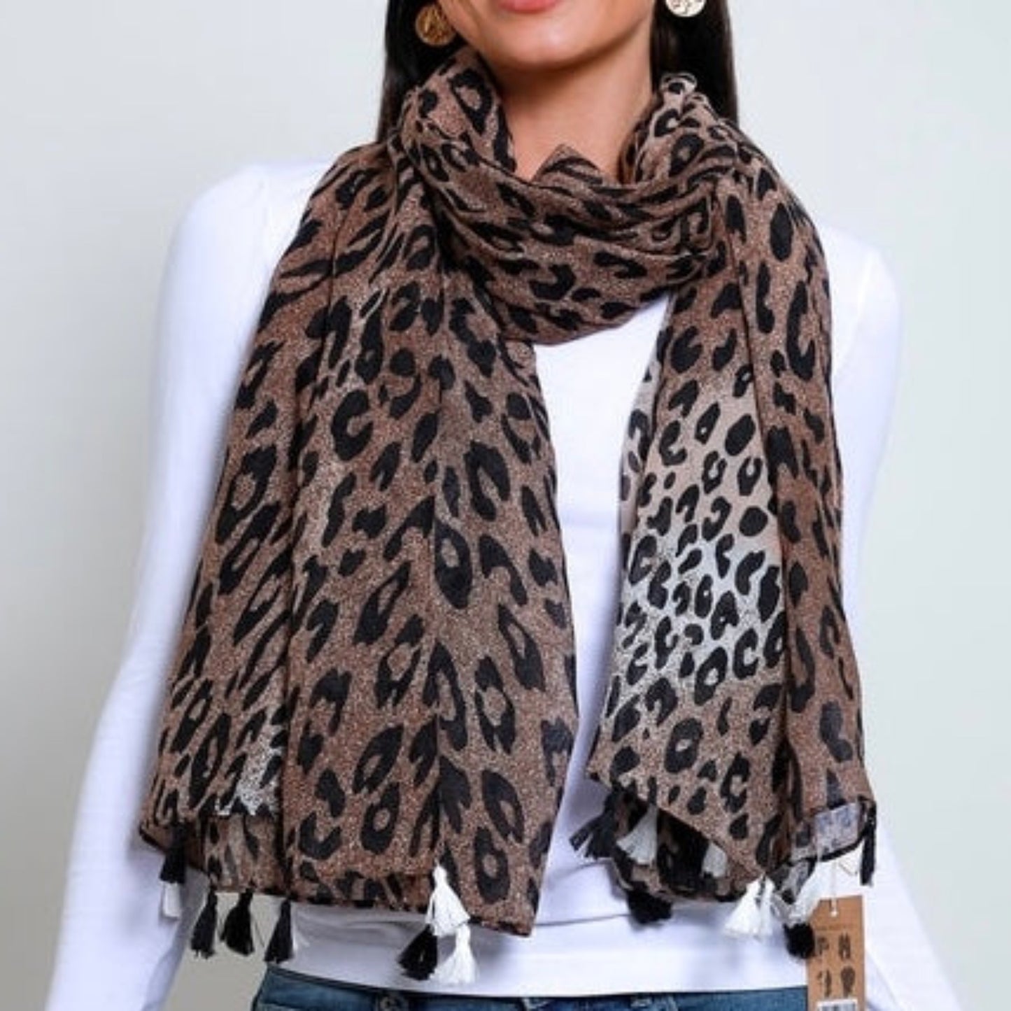 a lady wearing a leopard print scarf with a brown background an black leopard pattern