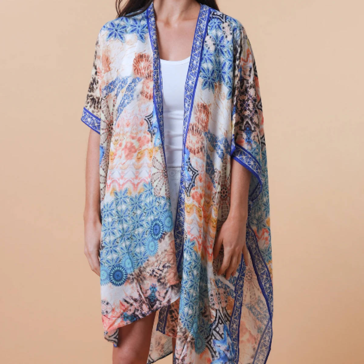 Woman wearing a blue abstract kimono against a beige background