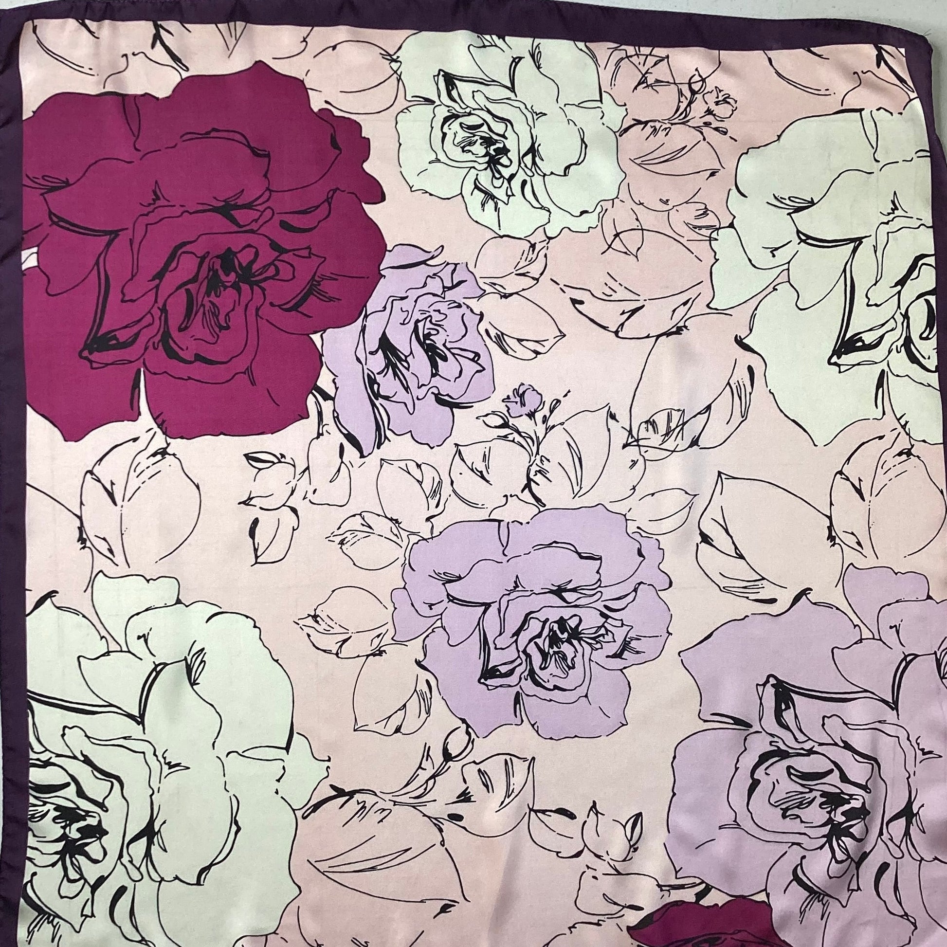 a satin ladies scarf with fuchsia pink and pale pink flowers and a dark purple border