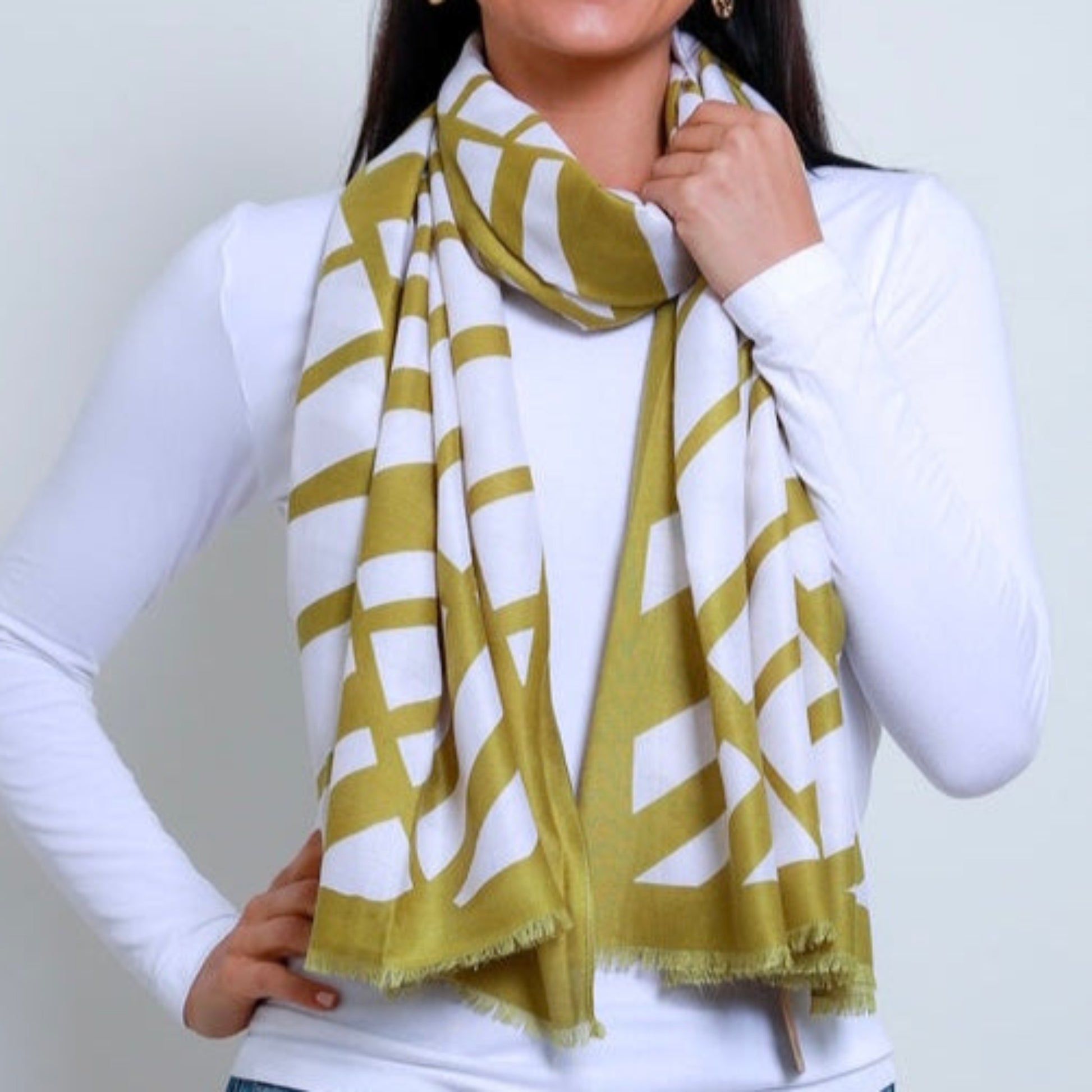 a lady wearing a white scarf with a pistachio green coloured geometric pattern