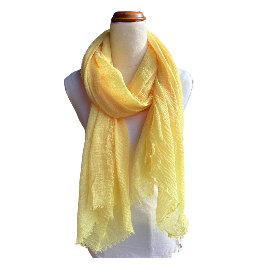 a ladies scarf that is a plain lemon yellow colour that has a textured weave and frayed edges on all sides