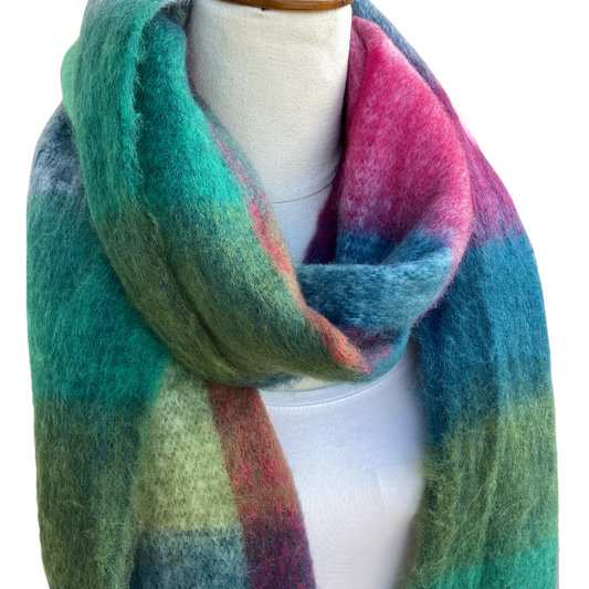 A fuzzy plaid scarf in shades of teal, green, blue, pink, and purple on awhite mannequin torso against a white background.