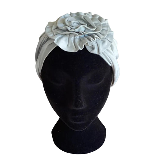 pale green hair turban on a black head mannequin