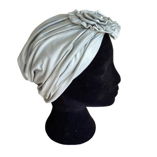 a sage green hair turban on a black mannequin head