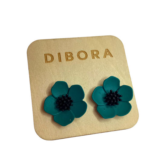 dark teal green flower stud earrings with a black centre. The earrings are mounted on a wooden card by brand Dibora.