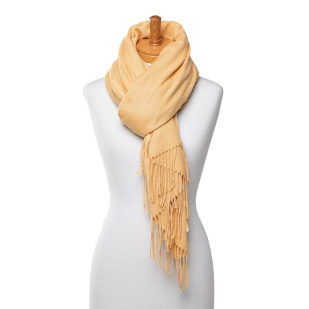 A soft and warm ladies scarf that is plain honey mustard colour with tassels. The scarf is tied around a mannequins neck.