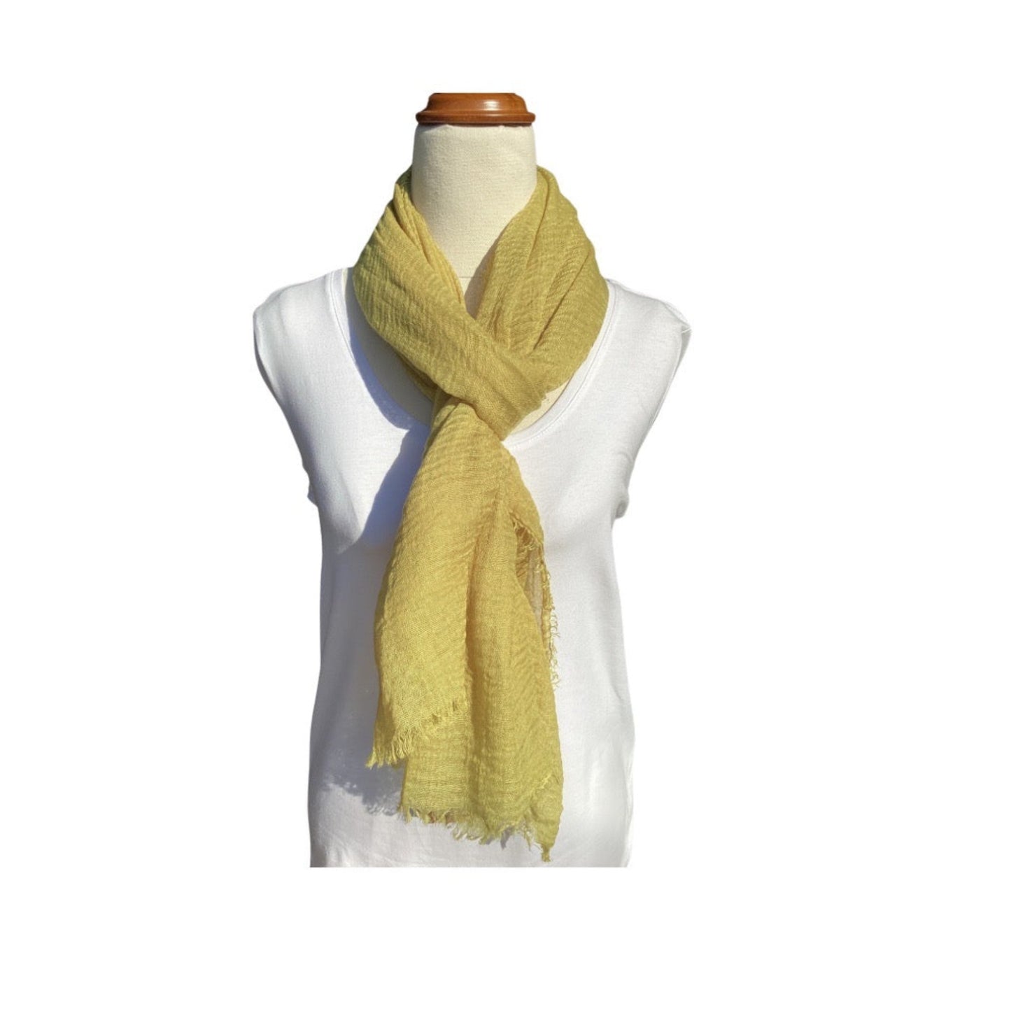 a plain ladies scarf that has an all over textured weave, frayed edge on all sides and is a plain chartreuse or pistachio colour